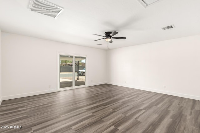 empty room with dark wood-style flooring, ceiling fan, visible vents, and baseboards
