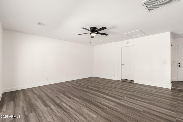 unfurnished room with a ceiling fan, attic access, dark wood-style flooring, and visible vents