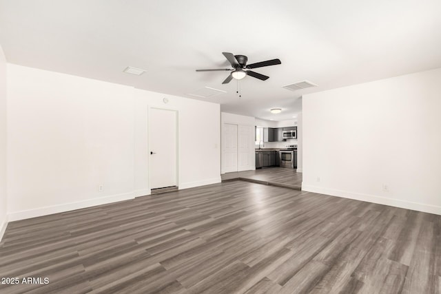 unfurnished living room featuring dark wood-style flooring, ceiling fan, visible vents, and baseboards