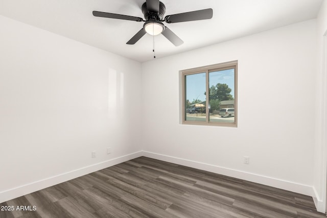 spare room featuring baseboards, a ceiling fan, and dark wood finished floors