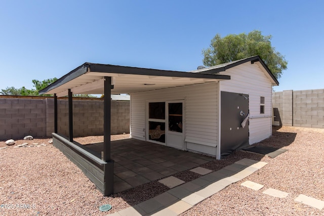 rear view of house featuring a fenced backyard and a patio area
