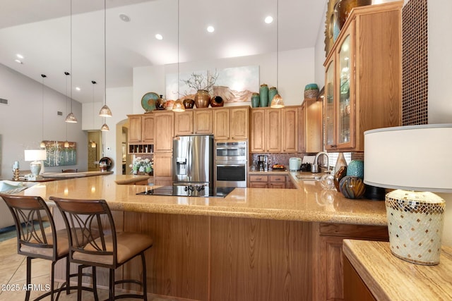 3166 N 158th Ave, Goodyear, AZ 85395 - kitchen featuring appliances with stainless steel finishes, light stone countertops, glass insert cabinets, a peninsula, and tasteful backsplash