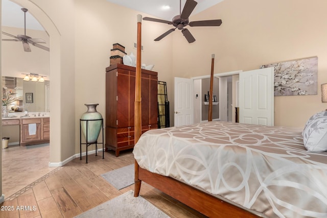 3166 N 158th Ave, Goodyear, AZ 85395 - bedroom with high vaulted ceiling, light wood-style flooring, arched walkways, ceiling fan, and ensuite bath