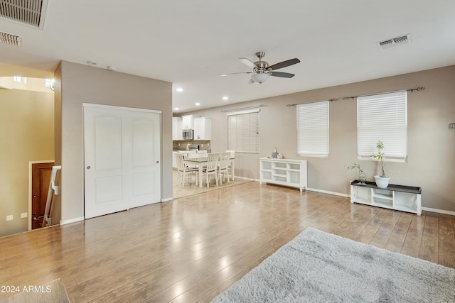 living room featuring light hardwood / wood-style floors and ceiling fan