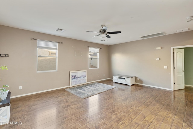 unfurnished living room with ceiling fan and dark hardwood / wood-style flooring