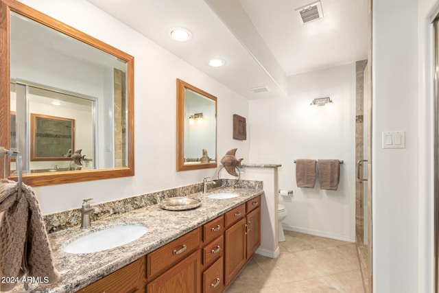 bathroom featuring toilet, vanity, tile patterned floors, and walk in shower