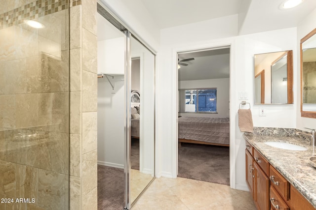 bathroom with tile patterned floors, ceiling fan, vanity, and tiled shower