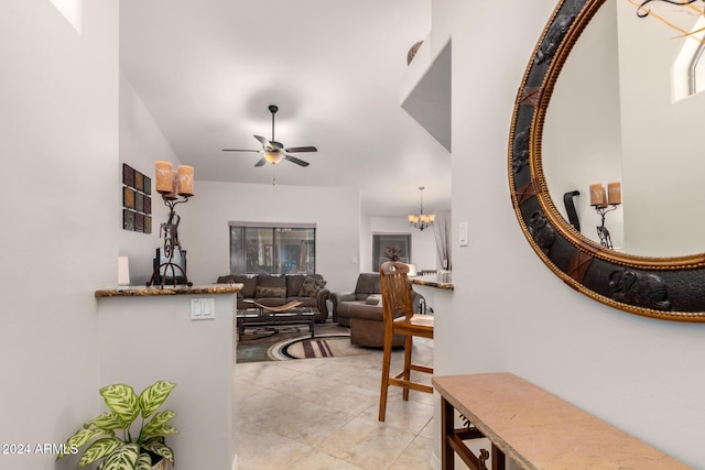 living room featuring light tile patterned floors and ceiling fan with notable chandelier