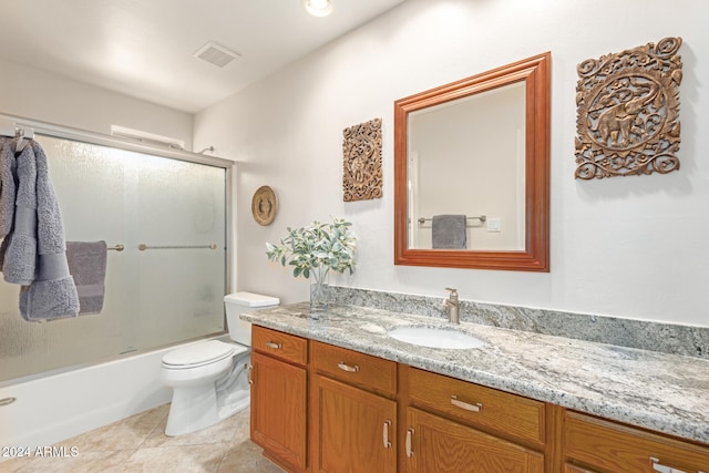 full bathroom featuring tile patterned floors, vanity, toilet, and combined bath / shower with glass door