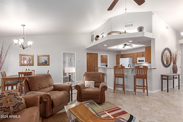 tiled living room with high vaulted ceiling and ceiling fan with notable chandelier