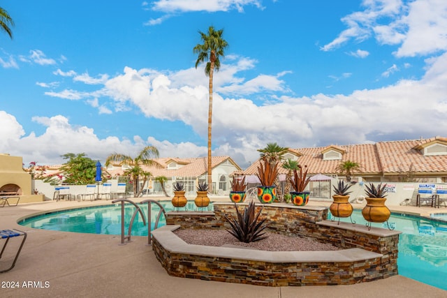 view of swimming pool featuring a patio area and an outdoor fireplace