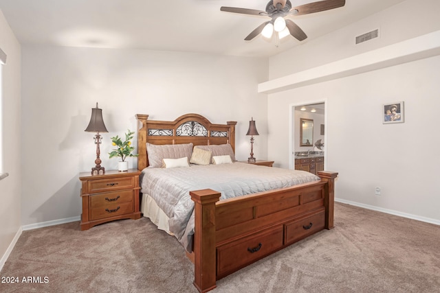 bedroom featuring connected bathroom, light colored carpet, and ceiling fan