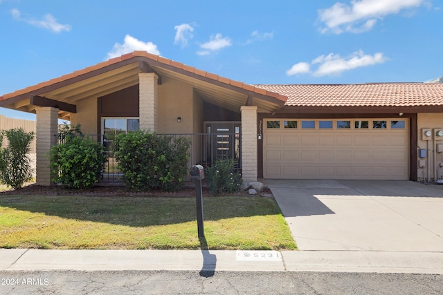 view of front of property featuring a garage and a front lawn