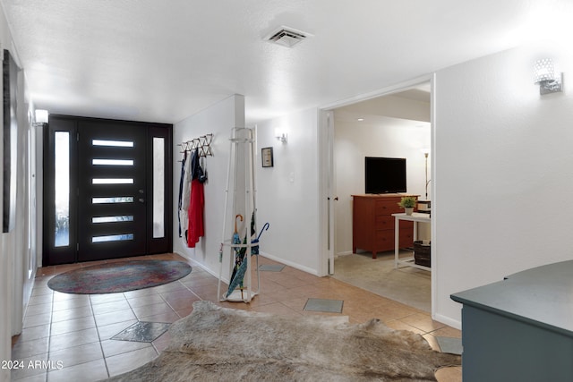 tiled foyer entrance featuring a textured ceiling