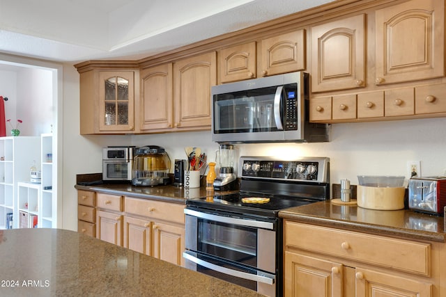 kitchen with light brown cabinetry, a textured ceiling, and appliances with stainless steel finishes