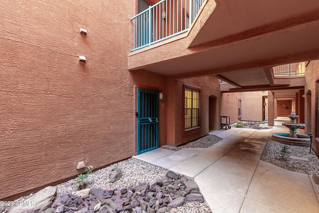 view of exterior entry with a balcony