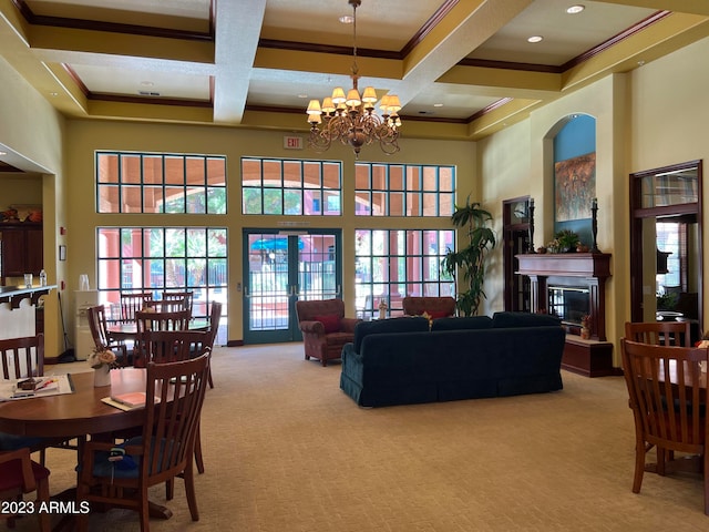 carpeted living room with a towering ceiling, crown molding, beamed ceiling, coffered ceiling, and a notable chandelier