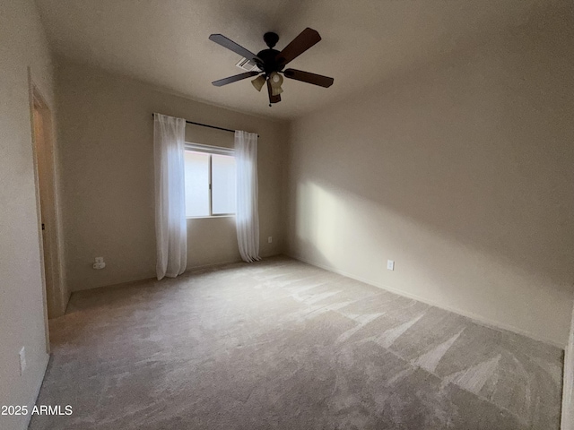 carpeted spare room featuring a ceiling fan