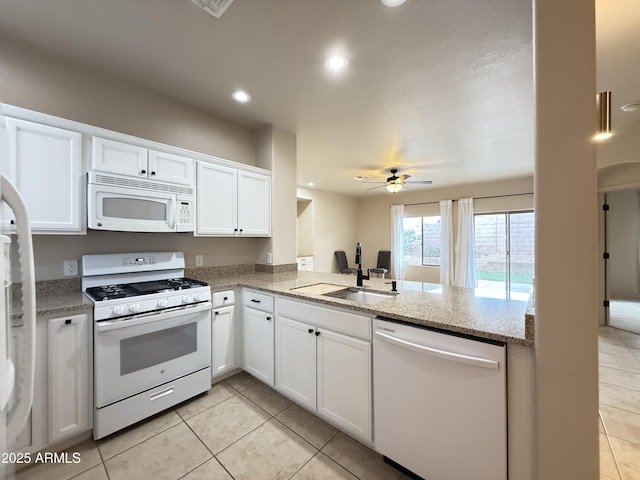 kitchen featuring light tile patterned floors, recessed lighting, white cabinets, a sink, and white appliances