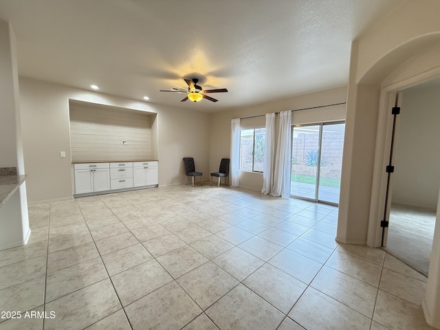 unfurnished living room with light tile patterned floors, ceiling fan, a textured ceiling, and recessed lighting