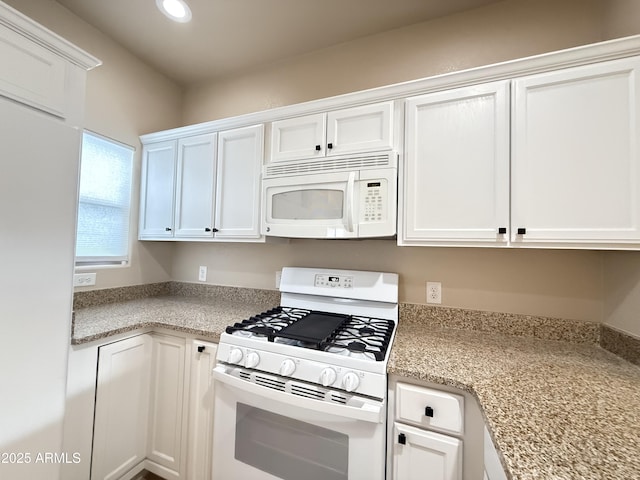 kitchen featuring recessed lighting, white appliances, and white cabinetry