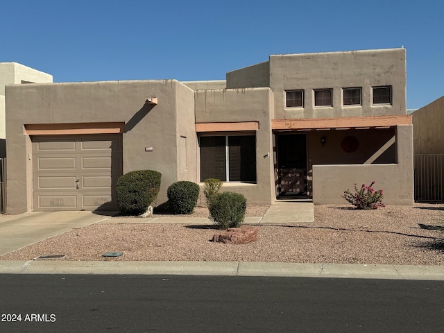 pueblo-style house featuring a garage