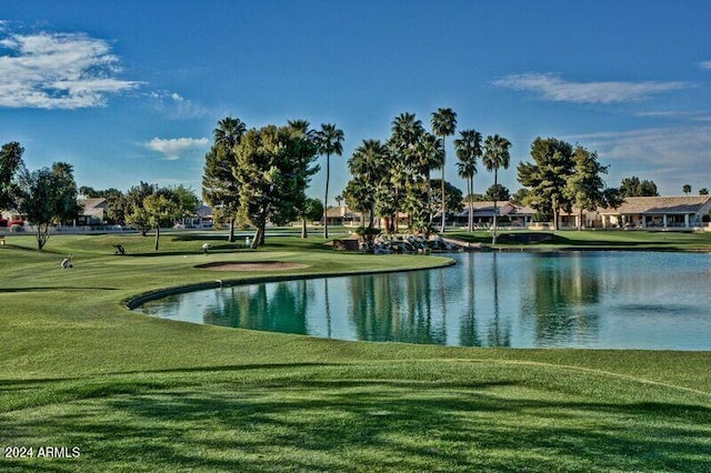 view of property's community with a water view and a lawn