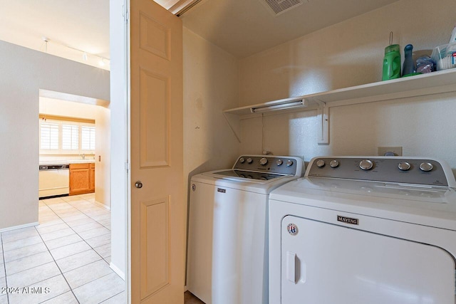 washroom with washer and clothes dryer and light tile patterned floors