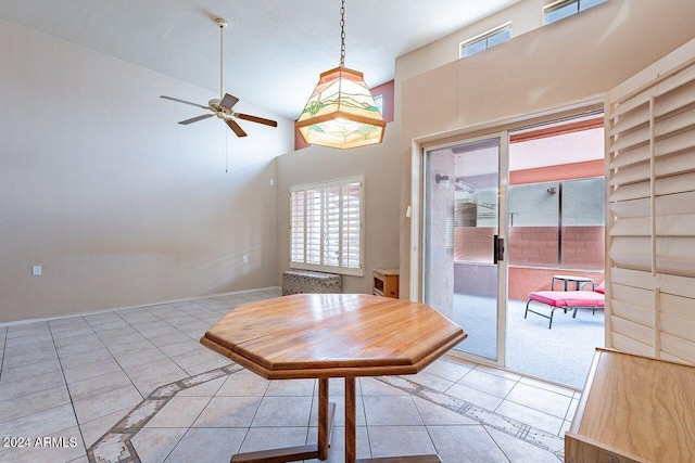 unfurnished dining area with ceiling fan and light tile patterned floors