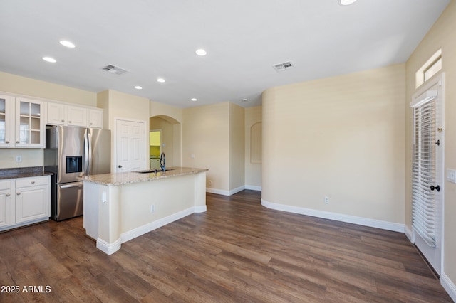 21017 W Edith Way, Buckeye, AZ 85396 - kitchen featuring stainless steel fridge, arched walkways, recessed lighting, a kitchen island with sink, and glass insert cabinets