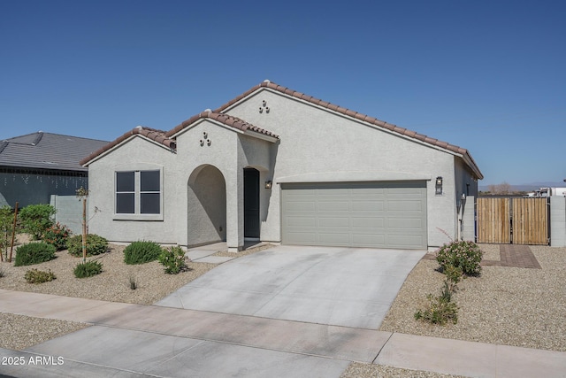 mediterranean / spanish house with driveway, a tile roof, and stucco siding