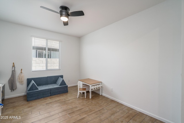 sitting room featuring light wood-style flooring, baseboards, and ceiling fan