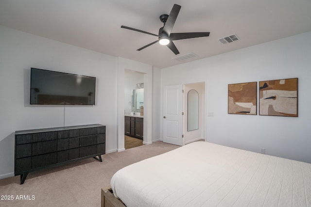 carpeted bedroom featuring ceiling fan, ensuite bathroom, visible vents, and baseboards