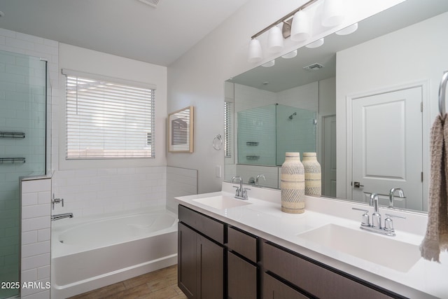 full bathroom with a bath, a shower stall, visible vents, and a sink