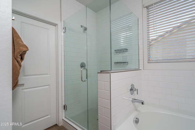 bathroom with a shower stall and a bathing tub