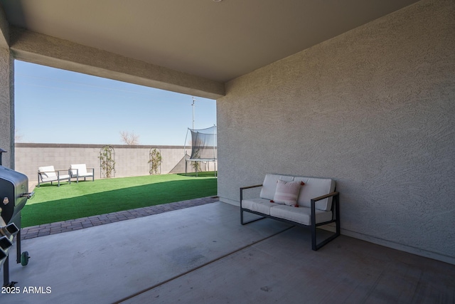 view of patio / terrace with a trampoline and fence