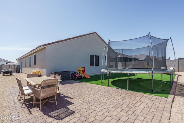 view of patio / terrace featuring outdoor dining space, a trampoline, and fence