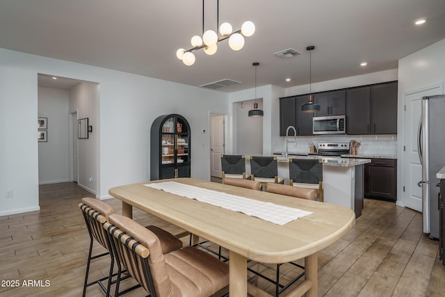 dining space featuring recessed lighting, light wood-type flooring, visible vents, and baseboards