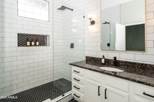 bathroom with tiled shower and vanity