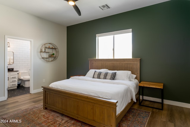 bedroom with ceiling fan, dark hardwood / wood-style floors, and ensuite bath