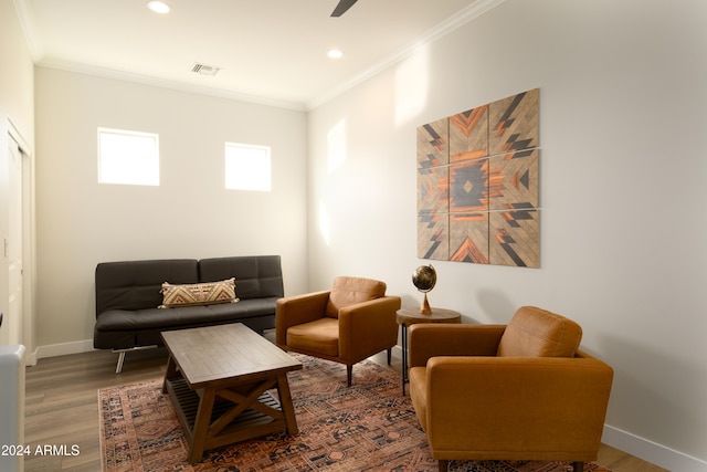 living area featuring hardwood / wood-style flooring and crown molding