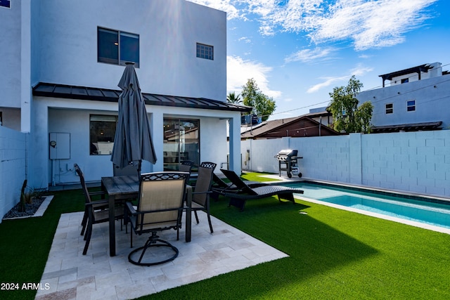 rear view of house with a fenced in pool, a yard, and a patio area