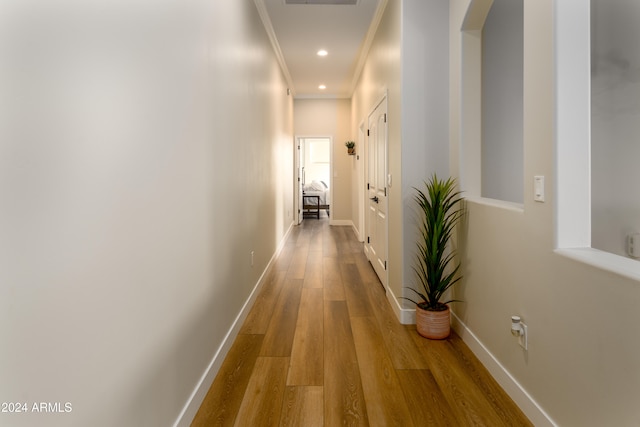 corridor featuring hardwood / wood-style flooring and crown molding