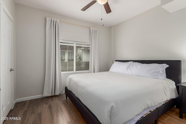 bedroom with a ceiling fan, baseboards, and wood finished floors