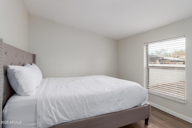 bedroom with baseboards and wood finished floors