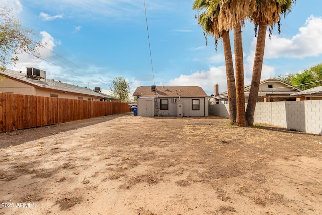 view of yard featuring central AC unit, an outdoor structure, and a fenced backyard