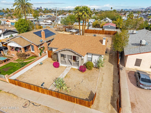 view of front of home with a shingled roof, a residential view, and fence