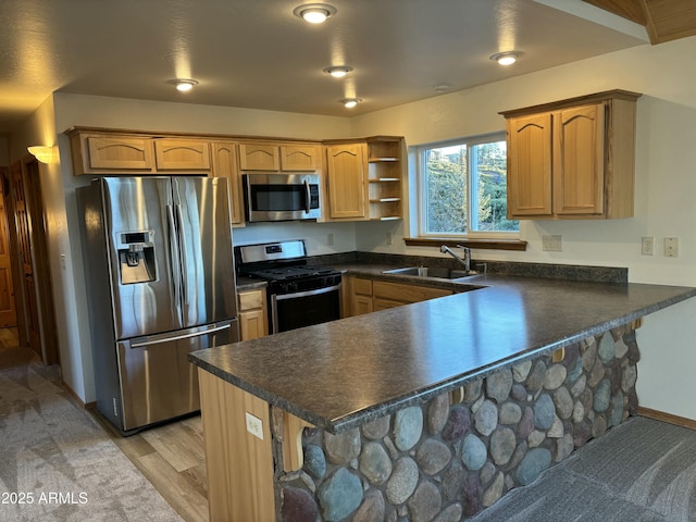 kitchen featuring stainless steel appliances, light hardwood / wood-style floors, sink, kitchen peninsula, and a breakfast bar