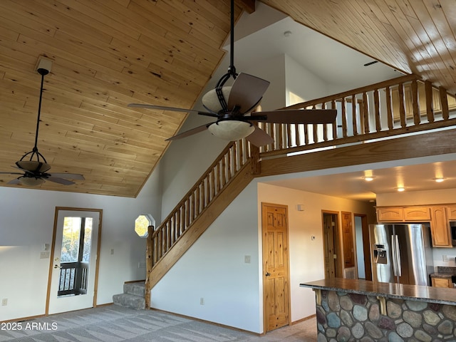 interior space featuring wooden ceiling, carpet floors, high vaulted ceiling, and ceiling fan