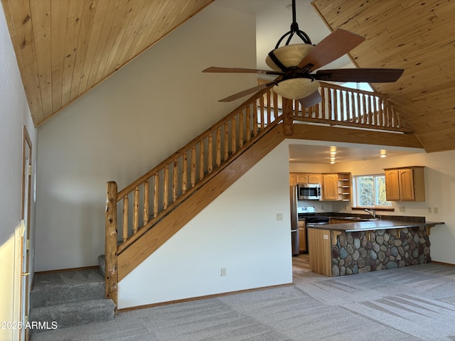 interior space with a kitchen bar, kitchen peninsula, light carpet, and stainless steel appliances